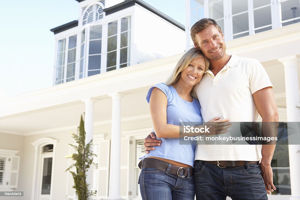 Pareja joven de pie fuera de casa de ensueño - Foto de stock de Casa libre de derechos