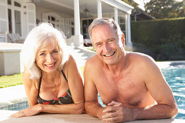 istock Senior Couple Relaxing by Outdoor Pool 106455625