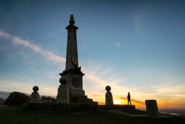 Spectacular sunset in the Chiltern Hills, Buckinghamshire, silhouetting a man looking up at the imposing monument to the Boer War that's on the very edge of Coombe Hill.