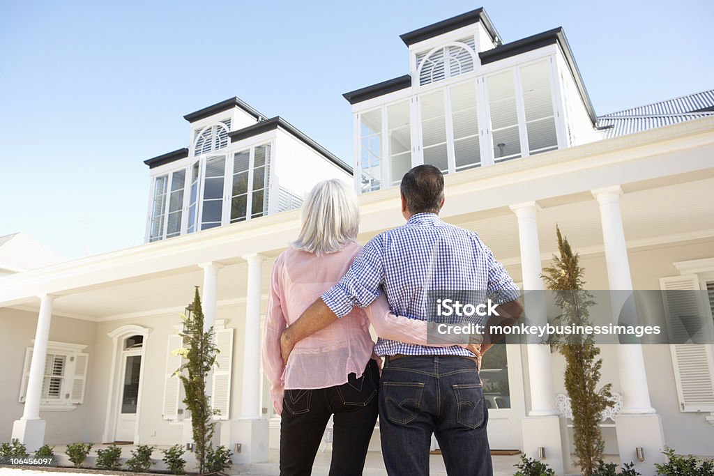 Sênior Casal em pé do lado de fora de casa dos sonhos - Foto de stock de Casa em Exposição royalty-free