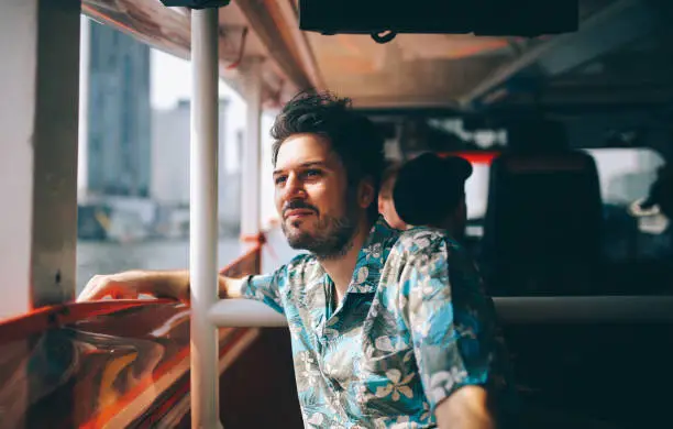 Photo of Young tourist riding on the Bangkok ferry boat