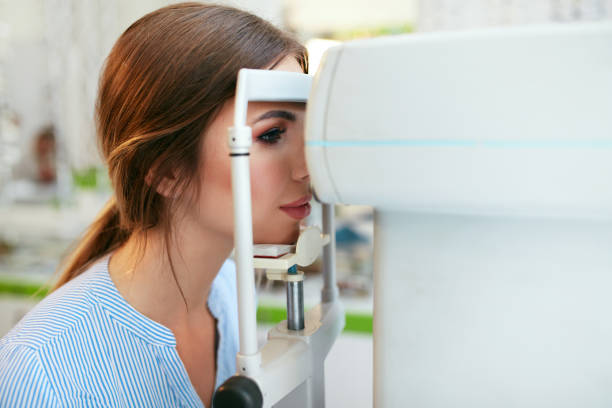 Eyesight Exam. Woman Checking Eye Vision On Optometry Equipment