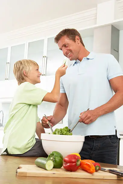 Photo of Father & Son Preparing Salad In Modern Kitchen