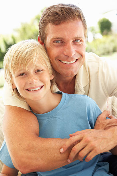 istock Portrait Of Father And Son Relaxing On Sofa 106456621