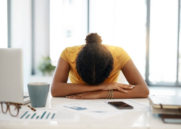 Work is making her miserable Shot of a young businesswoman with her head down on her office desk face down stock pictures, royalty-free photos & images