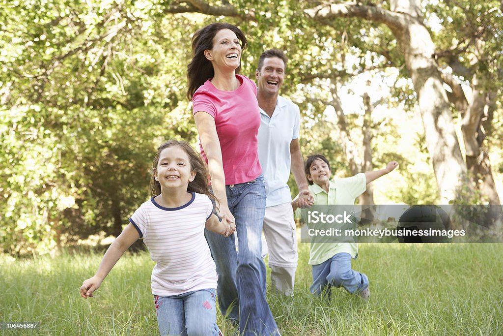 Family Enjoying Walk In Park  Woodland Stock Photo