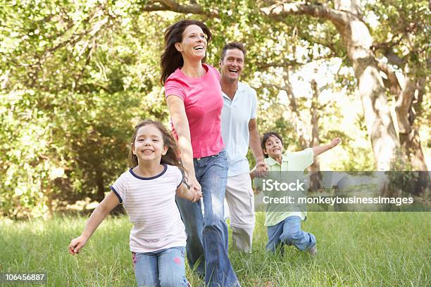 Family Enjoying Walk In Park Stock Photo - Download Image Now - Woodland, 4-5 Years, 40-49 Years