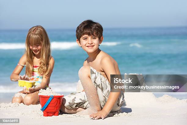 Photo libre de droit de Enfants De Construire Des Châteaux De Sable Sur La Plage Pour Les Fêtes banque d'images et plus d'images libres de droit de 4-5 ans