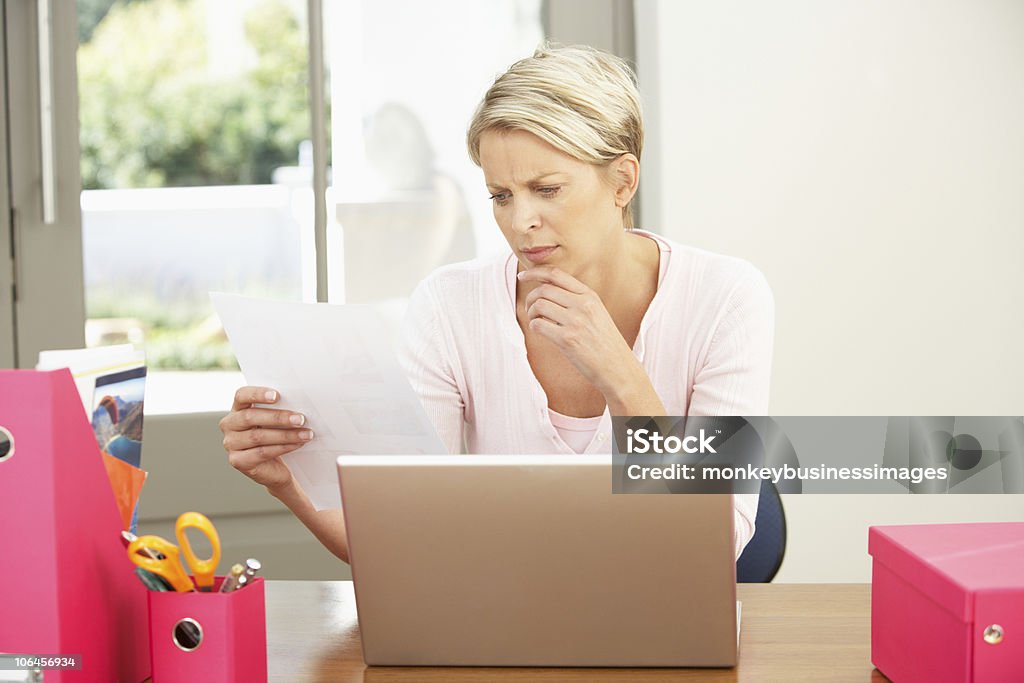 Donna utilizzando il computer portatile a casa - Foto stock royalty-free di Adulto