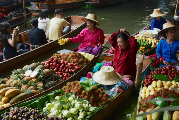 People sell food from boats at the floating market in Damnoen Saduak, Thailand. Damnoen Saduak, Thailand - May 15, 2008: Unidentified people sell food from boats at the floating market in Damnoen Saduak, Thailand. ratchaburi province stock pictures, royalty-free photos & images