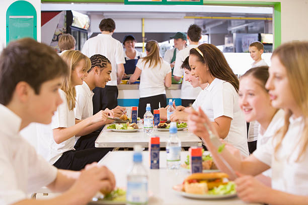 studenti del liceo mangiare nella caffetteria - cafeteria foto e immagini stock