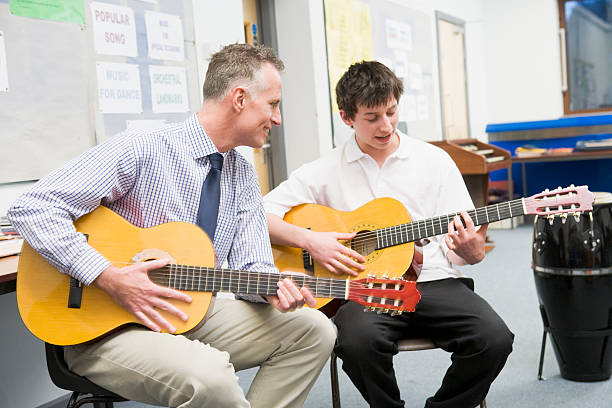istock Schoolboy and Teacher Playing Guitar in Music Class 106457065
