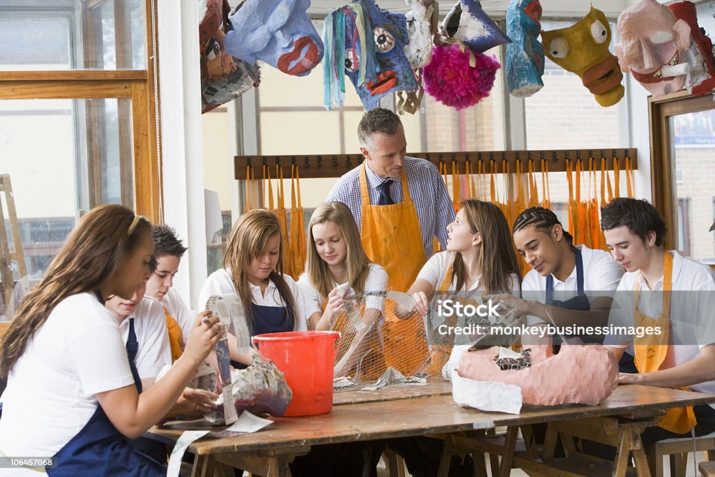 Petits écoliers et professeur assis autour d'une table dans l'art de classe - Photo de Art libre de droits