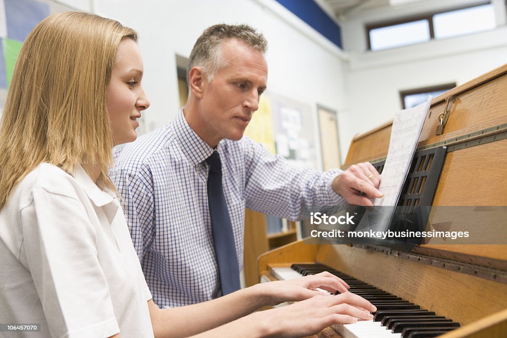 Niña en edad escolar tocando Piano y maestro en clase de música - Foto de stock de Piano libre de derechos