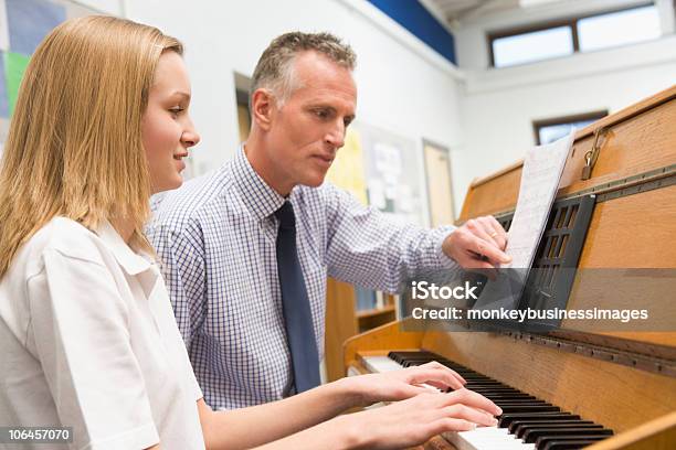 Niña En Edad Escolar Tocando Piano Y Maestro En Clase De Música Foto de stock y más banco de imágenes de Piano