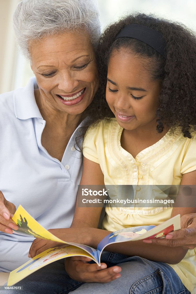 Avó e neta leitura enquanto sorrindo - Foto de stock de Avós e Avôs royalty-free