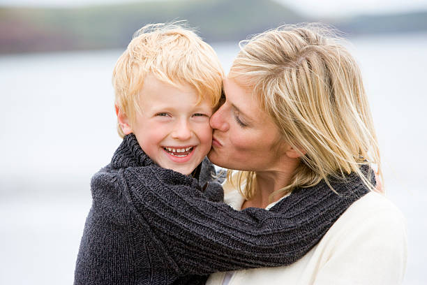 istock Mother kissing son at beach smiling 106457098