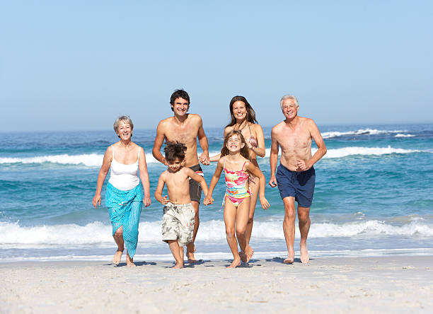 istock Three Generation Family On Holiday Walking Along Beach 106457128