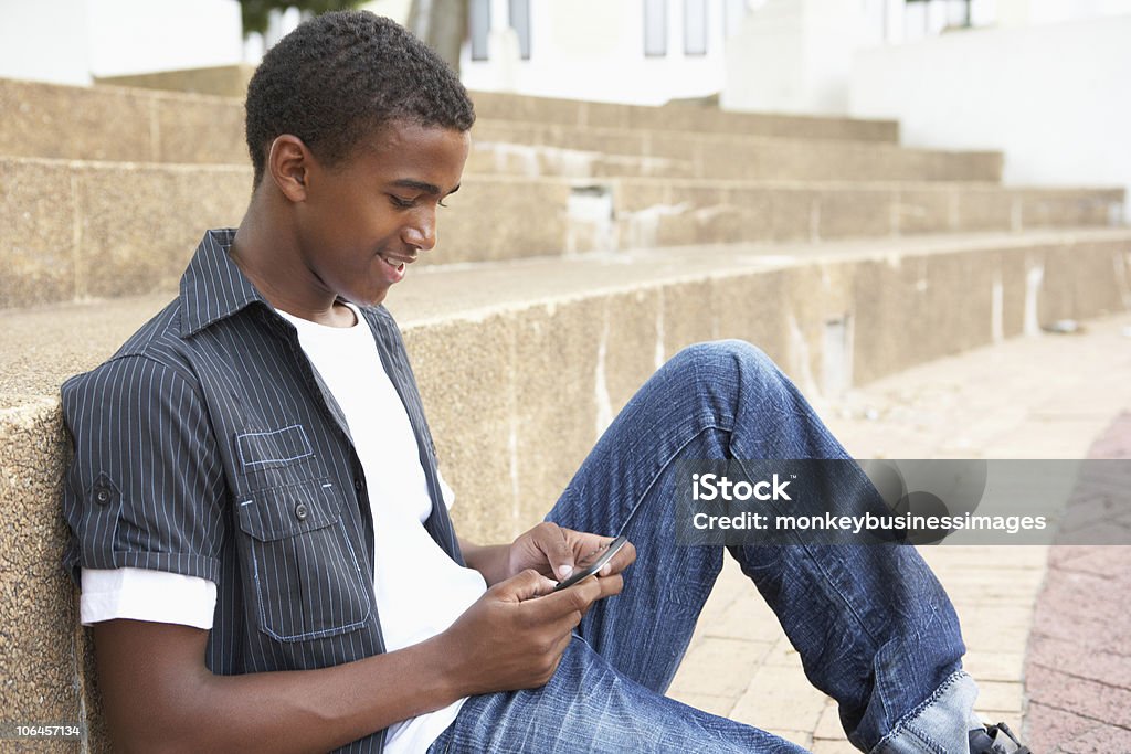 Männliche Teenager Studenten sitzen außen am College Schritte - Lizenzfrei Männlicher Teenager Stock-Foto