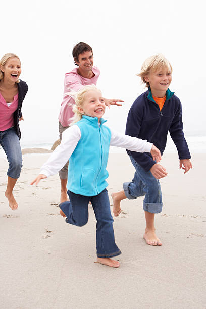 istock Young Family Running Along Winter Beach 106457159