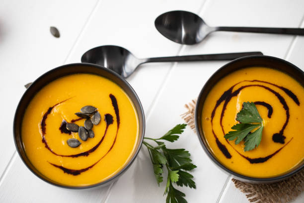 two black bowls with pumpkin soup stock photo
