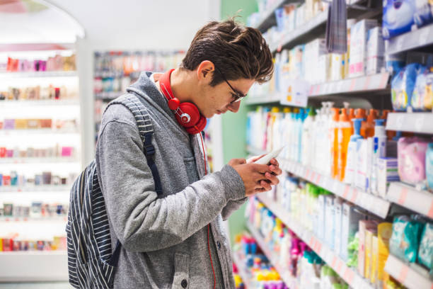 Students buy supplements for the gym Teenager shopping in supermarket, reading product information sheepish look stock pictures, royalty-free photos & images