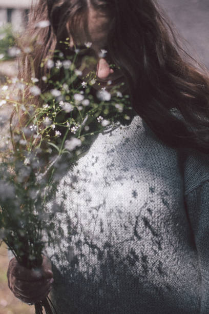 istock Young woman posing with flowers 1064573340