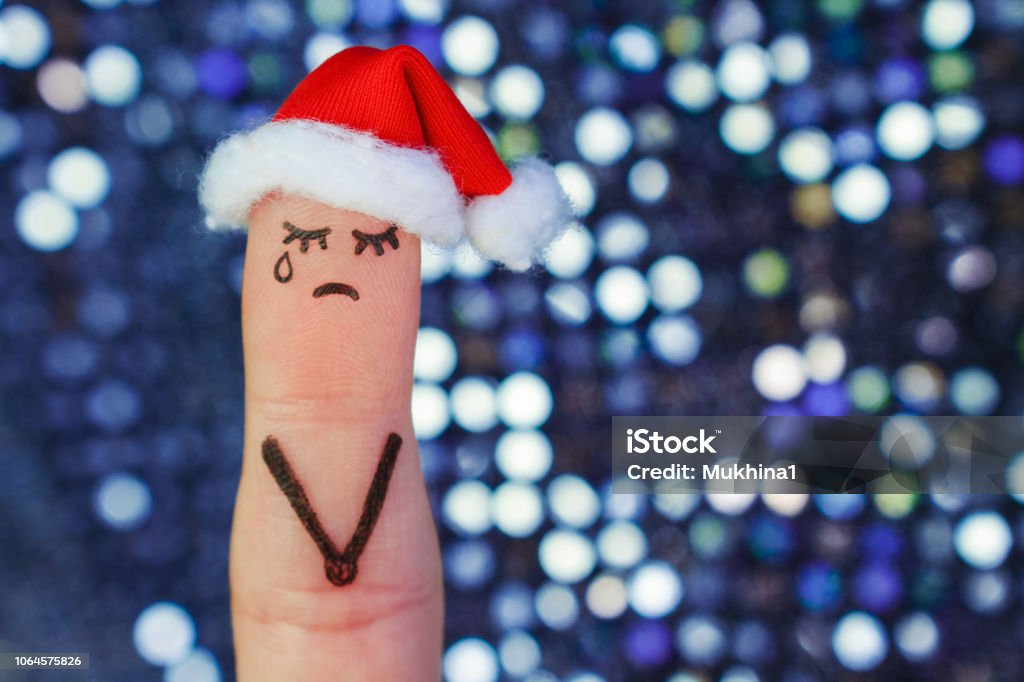 Finger art of lonely woman is crying. Concept people celebrate Christmas in new year hat. Toned image. Christmas Stock Photo