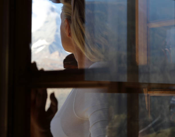 istock View through glass window to woman looking out 1064576664