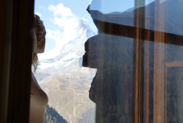 istock View through glass window to woman looking out 1064576694