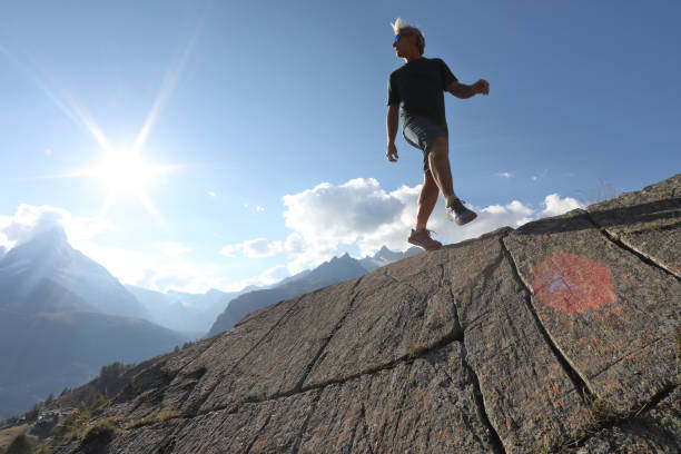 istock Man balances along rock ridge spine 1064576980