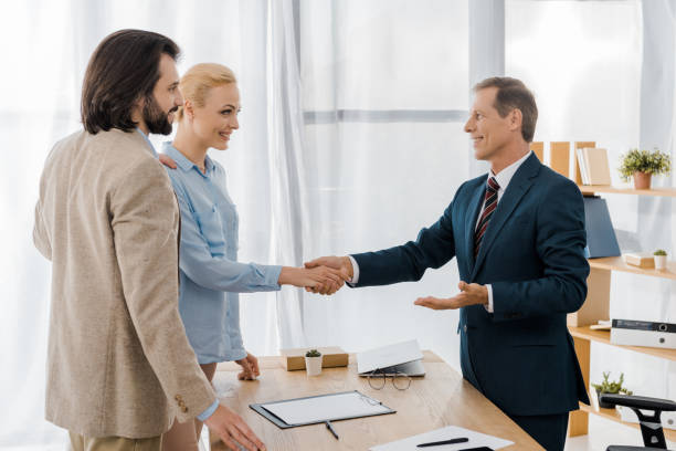 istock smiling woman and insurance agent shaking hands in office 1064577034