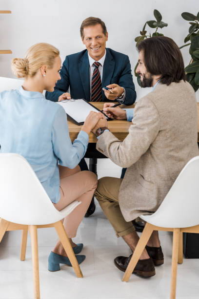 istock businessman holding keys while couple holding hands and signing contract 1064577232