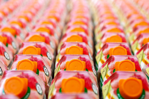 succhi di frutta sugli scaffali dei negozi nei supermercati. scatole di cartone colorate con tappo a vite in plastica. consistenza del succo. deliziosa bevanda rinfrescante. vista dall'alto. - packaging design foto e immagini stock