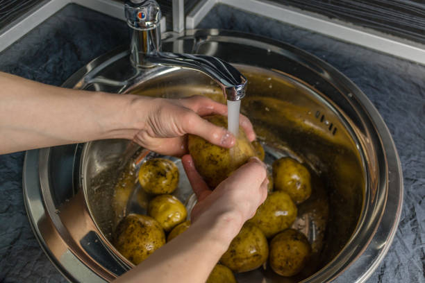 istock Wash vegetables under running water. Man's hands washing raw potatoes. 1064582438