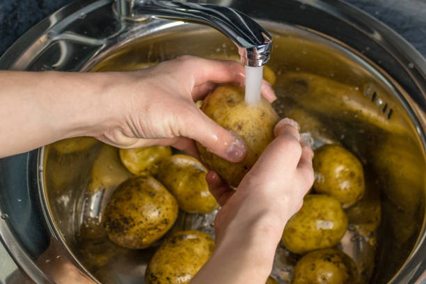 istock Wash vegetables under running water. Man's hands washing raw potatoes. 1064582450