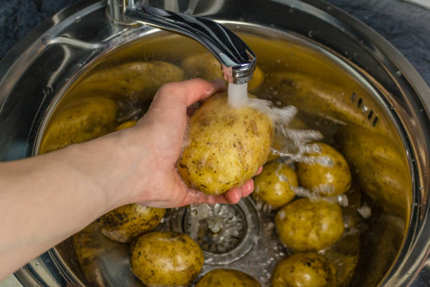 istock Wash vegetables under running water. Man's hands washing raw potatoes. 1064582458