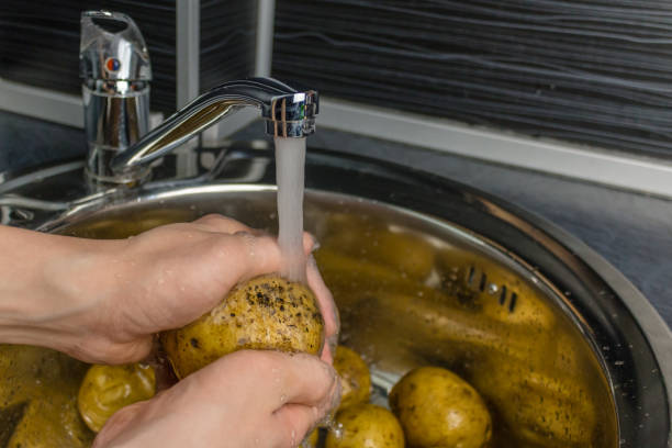 istock Wash vegetables under running water. Man's hands washing raw potatoes. 1064582460