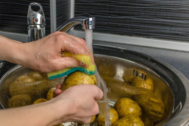 istock Wash vegetables under running water. Man's hands washing raw potatoes. 1064582464