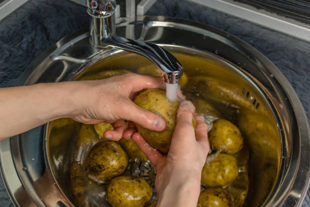 istock Wash vegetables under running water. Man's hands washing raw potatoes. 1064582466