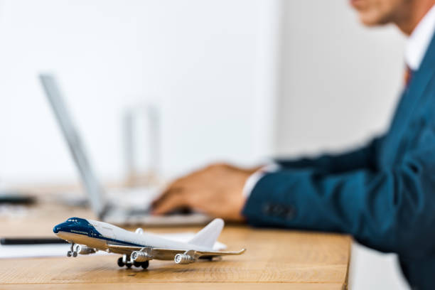 istock toy airplane at wooden table with office worker using laptop on blurred background 1064582862
