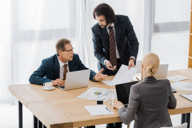 istock insurance agent showing contract to workers in office 1064583318