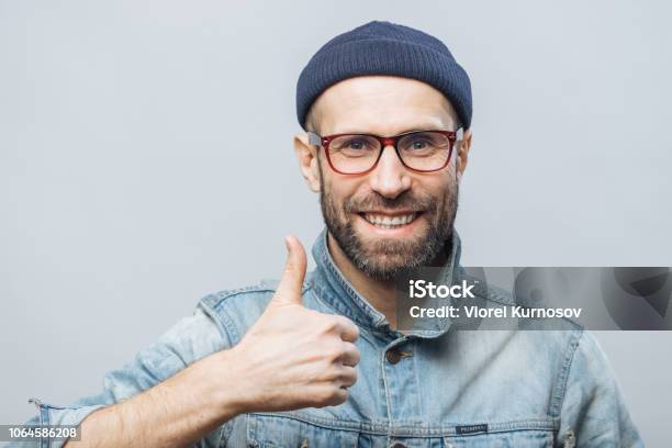 Portrait Of Glad Middle Aged Male Witth Thick Beard And Mustache Shows His Satisfaction With Something Raises Thumb Has Positive Smile On Face Isolated Over White Background Happiness Concept Stock Photo - Download Image Now