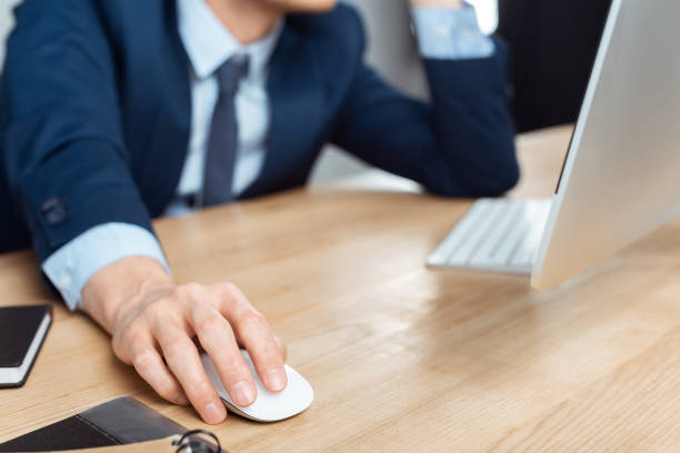 istock cropped image of businessman in eyeglasses working at table with computer mouse in modern office 1064589100