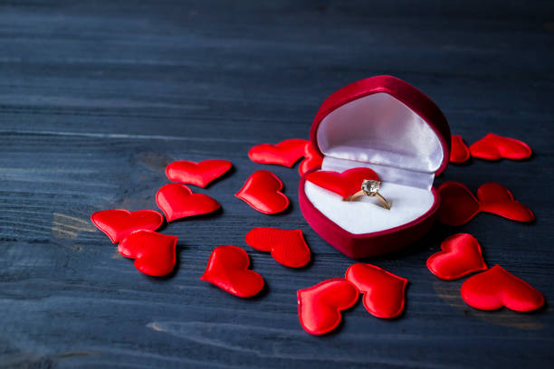 istock Engagement ring in a red box on a love hearts background. Valentine's day 1064590636