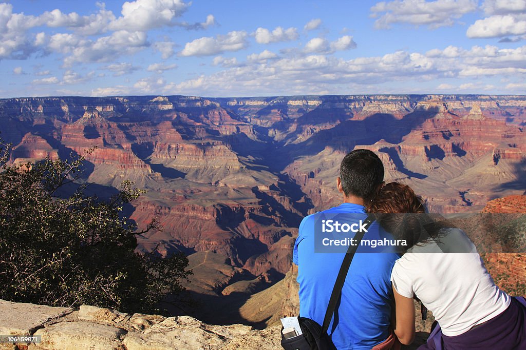 Casal em amor sentado no penhasco e assistir o Grand Canyon - Foto de stock de Grand Canyon royalty-free