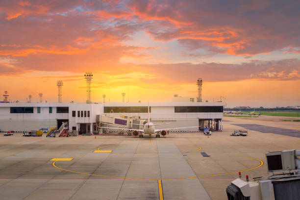 airplane ready for boarding in a airport hub at sunset