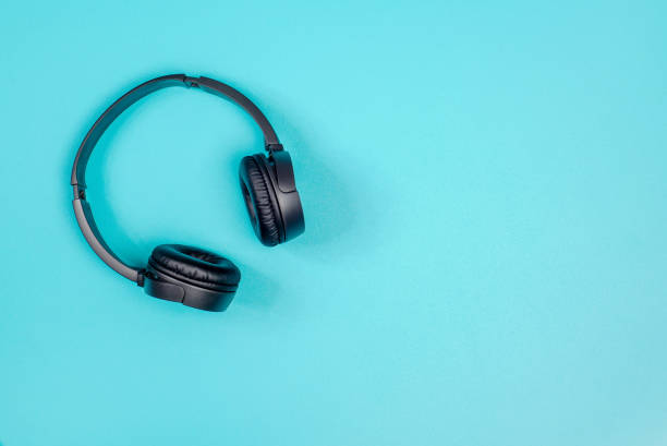 istock Black headphone on pastel green metal table background. 1064591850