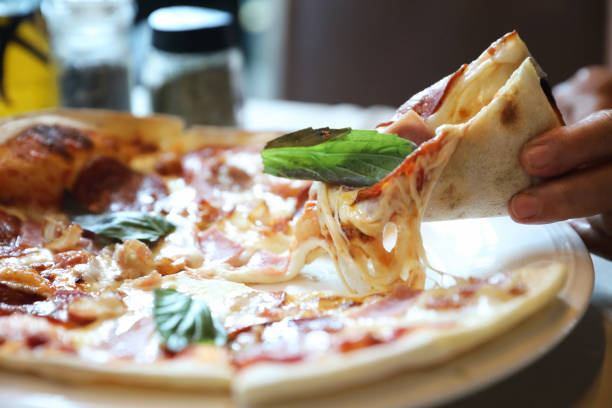 istock pepperoni bacon and ham pizza in restaurant background 1064598784
