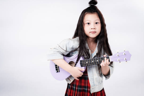 istock The little girl is playing ukulele 1064598972